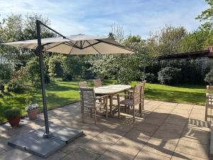 a table and chairs under an umbrella on a patio at Ferienhaus Bothmer in Schwarmstedt