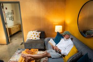 a man sitting on a couch reading a book at The Speckled Trout Outpost in Damascus