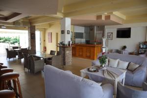 a living room with couches and tables and a kitchen at Platanes Hotel Apartments Rethymno in Platanes