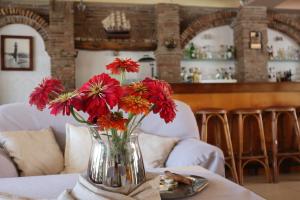 a vase filled with red flowers on a table at Platanes Hotel Apartments Rethymno in Platanes