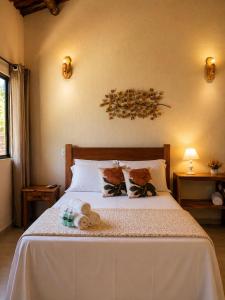 a bedroom with a white bed with two stuffed animals on it at Refúgios de Mauá - Chalé Jardins de Maria in Visconde De Maua