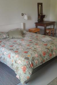 a bedroom with a bed with a floral comforter at gite du canal in Ormoy