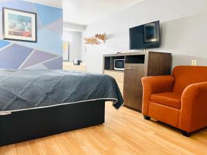 a bedroom with a bed and a chair and a television at Hometown INN in Berea