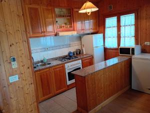 a kitchen with wooden cabinets and a white refrigerator at Casa Carballar in Oia +33 photos