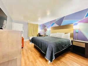 a bedroom with a bed and a colorful wall at Hometown INN in Berea