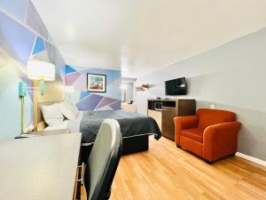 a hotel room with a bed and a chair at Hometown INN in Berea