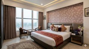 a hotel room with a bed and a desk at Hotel Banana Tree & Banquets 5 Min From Anand Vihar Bus Terminal and Vaishali Metro Station in Ghaziabad +45 photos
