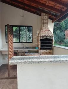 a kitchen with a stone counter top with a fireplace at Rancho Macalé Balneário de Rancharia Sp in Rancharia
