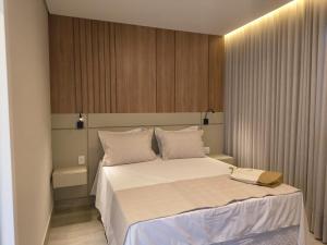 a bedroom with a large bed with white sheets and pillows at Píer 135 Escarpas in Capitólio +285 photos