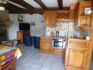 a kitchen with wooden cabinets and a stove top oven at Gîte des Oiseaux in Bieuzy-les Eaux +6 photos
