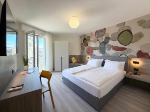 a bedroom with a large bed and a desk with a desk at Hotel Universal in Caorle +77 photos