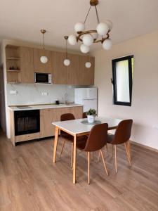a kitchen and dining room with a table and chairs at Hil's Bay View - Terra in Lepetani