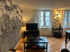 a living room with a coffee table and a television at Duplex in Honfleur