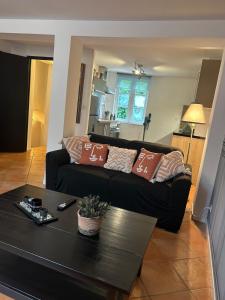 a living room with a black couch and a table at Duplex in Honfleur