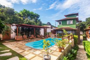 ein Garten mit Swimmingpool und ein Haus in der Unterkunft Villa Arpoador | Praia Piscina Churrasqueira Estacionamento | By Buzios Rentals in Costa