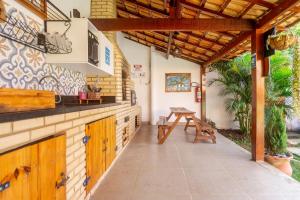 eine Terrasse mit Holzdach und einem Tisch in der Unterkunft Villa Arpoador | Praia Piscina Churrasqueira Estacionamento | By Buzios Rentals in Costa