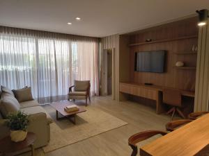 a living room with a couch and a tv at Píer 135 Escarpas in Capitólio