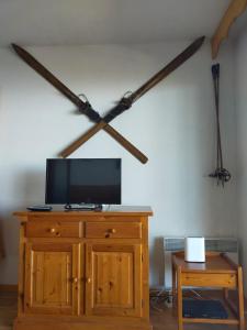 a room with a tv on top of a wooden dresser at Chalet Chamrousse – Balcon avec vue Proche Pistes in Chamrousse