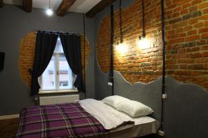 Lviv Loft Apartments في إلفيف: غرفة نوم بسرير وجدار من الطوب