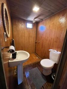 a bathroom with a white toilet and a sink at Campo Eden in Capitán Miranda