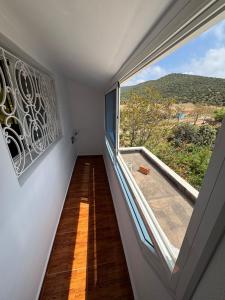 a room with a large window with a view at Dar Idurar in Imouzzer du Kandar
