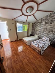 a bedroom with two beds and a brick wall at Dar Idurar in Imouzzer du Kandar +27 photos