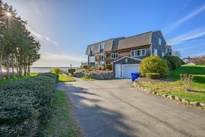 a house with a driveway in front of the ocean at Cape Cod Waterfront with Stunning Views in Buzzards Bay