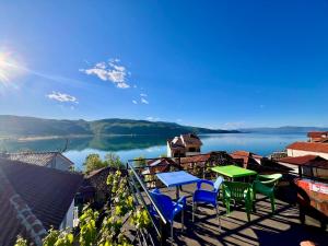 a balcony with chairs and a table and a view of a lake at Dejani Guest House in Pogradec