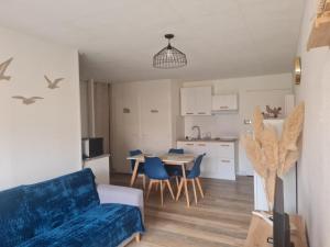 a living room with a couch and a table with chairs at Le cocon Sétois - T2 et garage privé in Sète