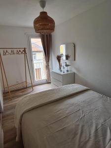a bedroom with a large bed and a window at Le cocon Sétois - T2 et garage privé in Sète
