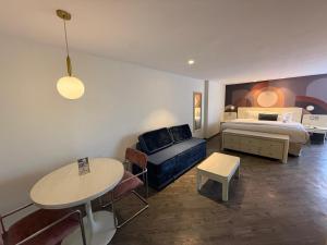 a bedroom with a bed and a table and a bed and a couch at Hotel Century Reforma in Mexico City