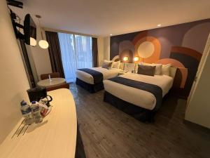 a hotel room with two beds and a table at Hotel Century Reforma in Mexico City