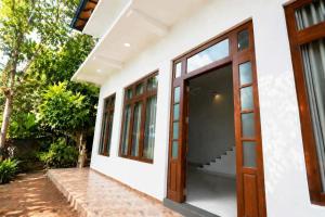 a white house with wooden doors and windows at Prime Inn Kandy in Kandy