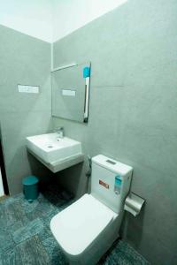 a bathroom with a white toilet and a sink at Prime Inn Kandy in Kandy +3 photos