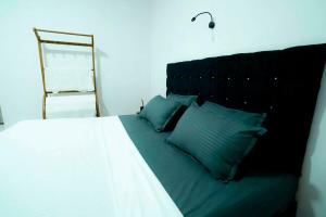 a bedroom with a bed with blue pillows and a ladder at Prime Inn Kandy in Kandy