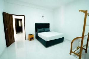 a bedroom with a bed in a white room at Prime Inn Kandy in Kandy