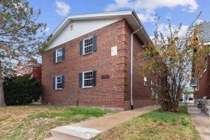 a red brick building with a tree in front of it at Private 1BR for Two on Morganford in Saint Louis