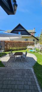 a picnic table and two chairs and an umbrella at Panorama Apartment in Nowy Targ
