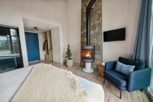 a bedroom with a bed and a chair and a fireplace at Pyramid Lake Lodge in Jasper