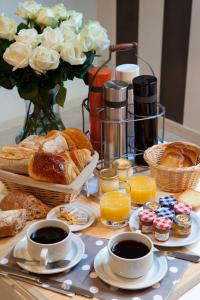 a table with a tray of breakfast foods and flowers at Vign 'Appart in Nuits-Saint-Georges +5 photos