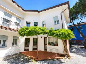a white house with a tree in front of it at Casa Francesca - Agenzia Cocal in Caorle