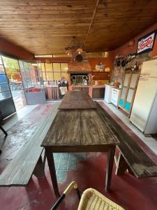 a kitchen with three wooden tables in a room at Casa los Molles Hostel in Maimará