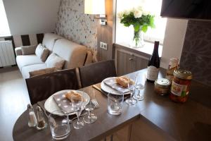 a table with two plates of food and wine glasses at Vign 'Appart in Nuits-Saint-Georges