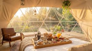 a tray of food on a bed in a tent at Vilodge in Charrúa