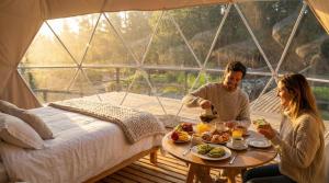 a man and woman eating food in a tent at Vilodge in Charrúa