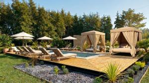 a pool with chairs and umbrellas in a yard at Vilodge in Charrúa
