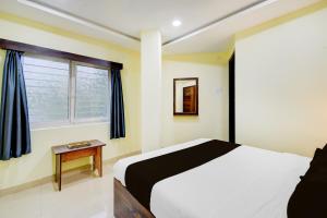 a bedroom with a large bed and a window at Hotel O Hotel R Pacific in Hyderabad +21 photos