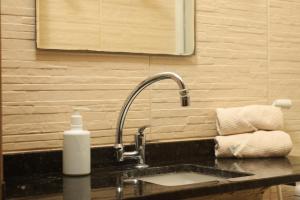 a bathroom sink with a faucet and a bottle of soap at Pousada Casa Boa Milagres a beira mar ideal para curtir a Rota dos Milagres in Barra do Camaragibe +181 photos
