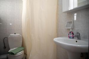 a bathroom with a white toilet and a sink at Fay's Studios Leros in Lakkíon +13 photos