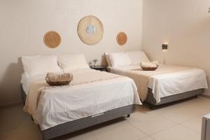 a bedroom with two beds and a mirror on the wall at Pousada Casa Boa Milagres a beira mar ideal para curtir a Rota dos Milagres in Barra do Camaragibe